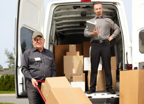 Moving team handling boxes safely during a van loading process