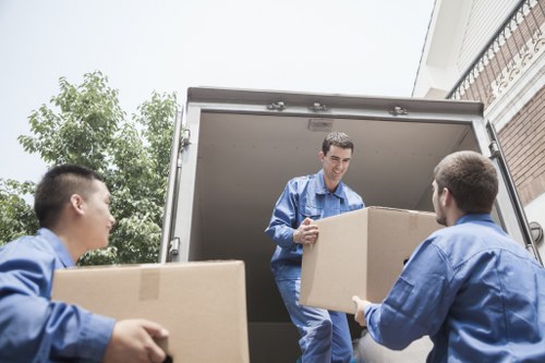 Local movers carrying household items in a London flat