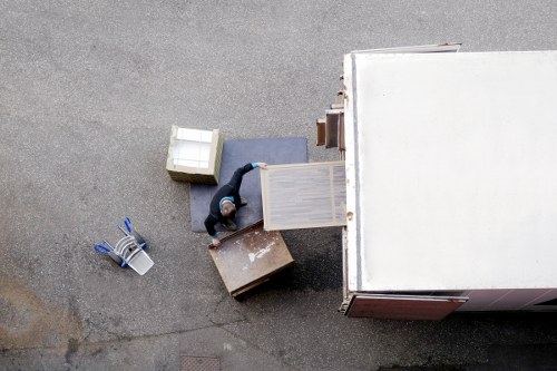 Professional movers carrying furniture through a London flat entrance