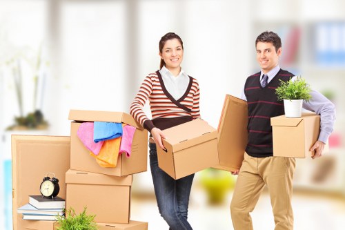 Movers carrying furniture in a London flat with stairs