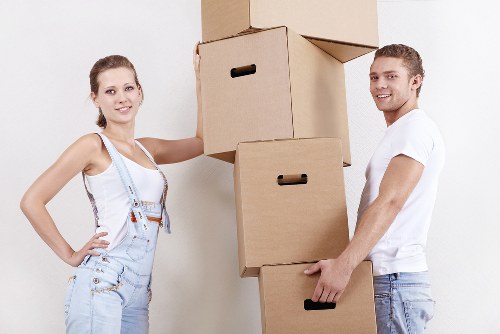 Movers carrying furniture down the stairs in a London property